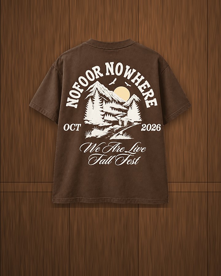 We Are Live Fall Fest tee in dark brown on a wood wall